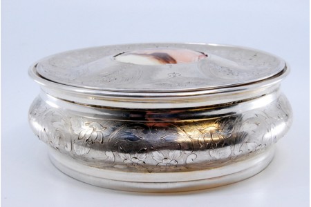 Guarda joias em prata de forma circular com motivos vegetalistas gravados envolvendo cartela com dama antiga em esmalte com tampa amovível.